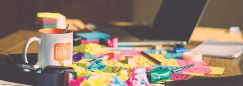 sticky notes and laptop sit on a desk