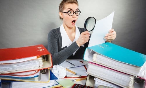 Shocked secretary examining documents.