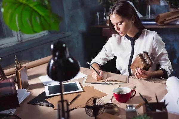 young woman working with cup of coffee