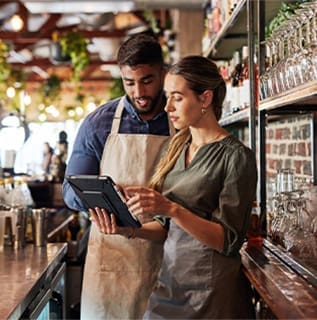 Man and woman review restaurant details on tablet